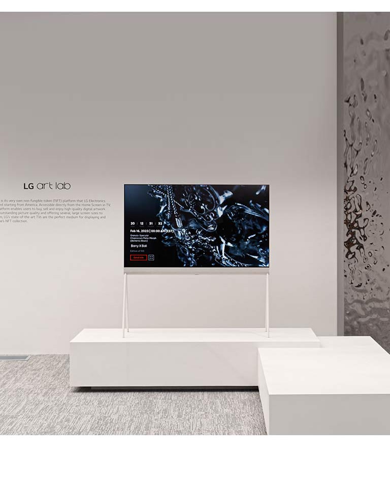 Slika štafelaja u beloj prostoriji prikazuje digitalno umetničko delo sa crnom skulpturom na ekranu. Na srebrnoj fizičkoj skulpturi sa desne strane TV-a vidi se odraz prostorije.